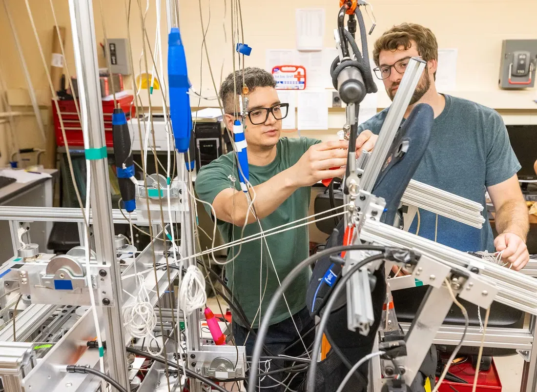 Two graduate students work together in lab.